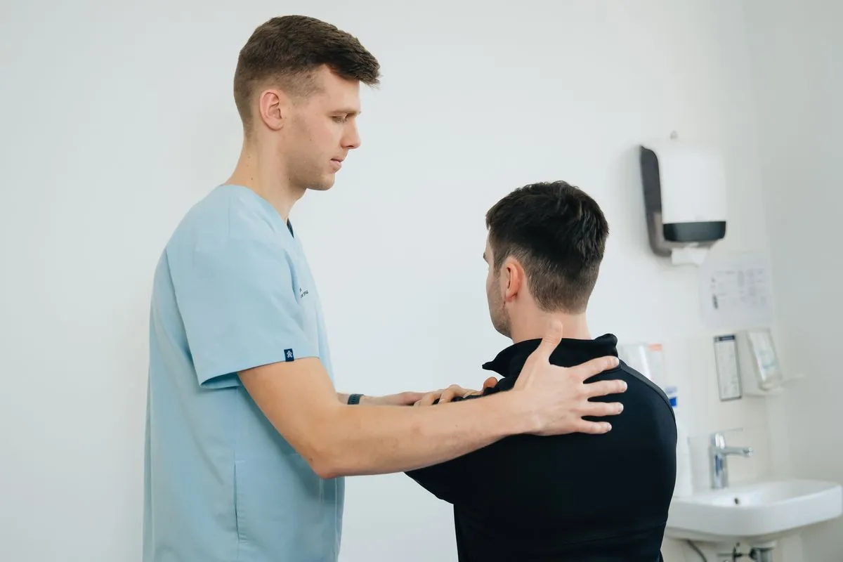 A physiotherapist assessing a patient's shoulder in a bright clinic